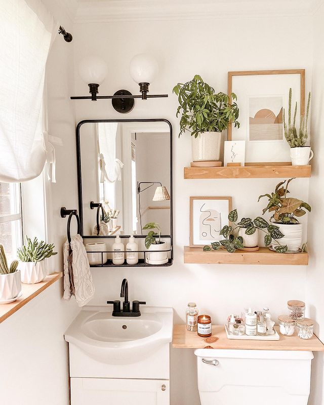small bathroom with wood shelves over the toilet and plants