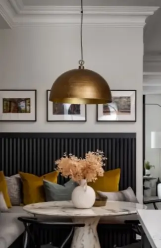 cozy corner dining nook with round marble, table, Wishbone-style chairs, mustard and gray velvet pillows, Aged Brass Dome Pendant Light Fixture, wall art frames